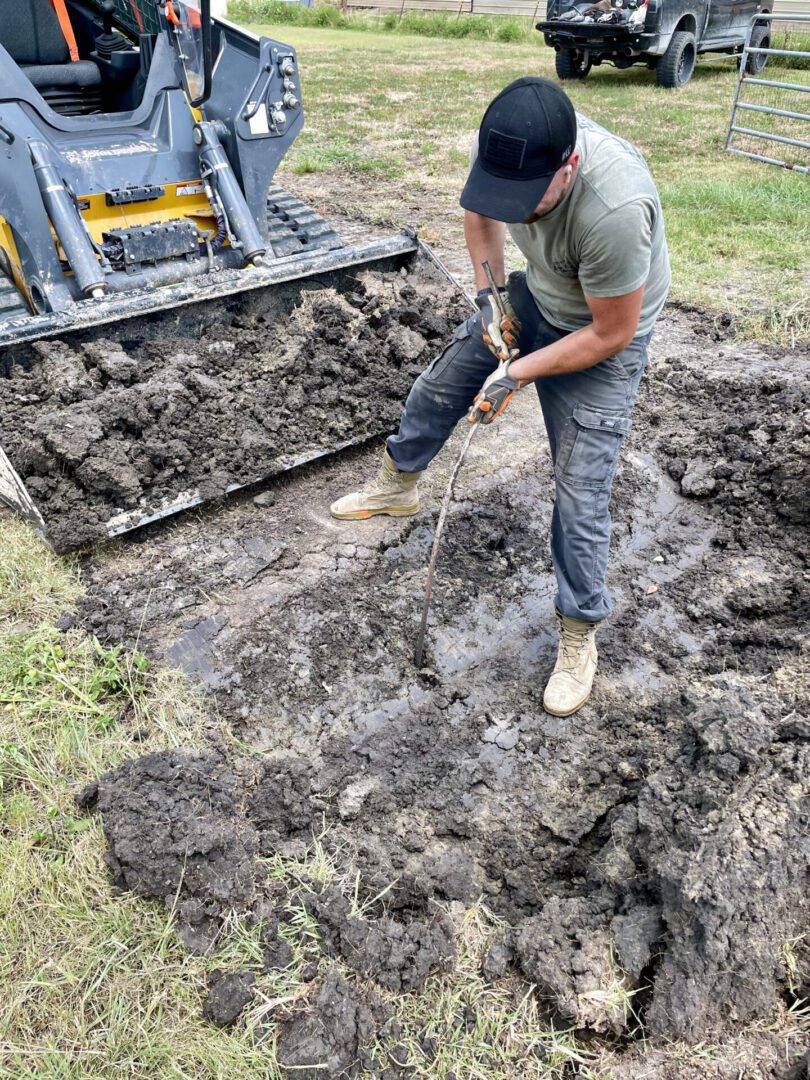 A Man Pulling a Tree From a Dug Out Pit