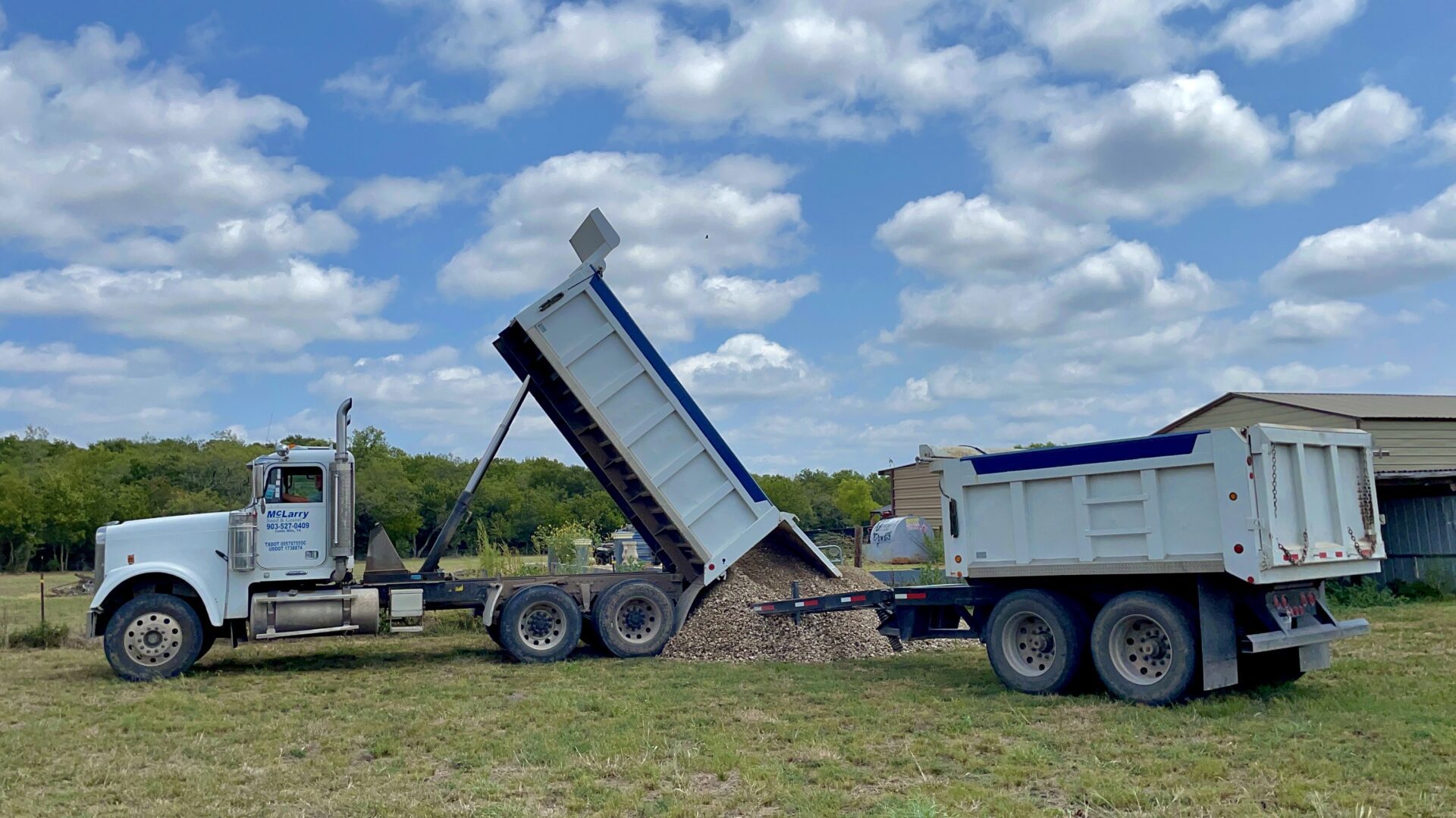 A Drop Truck Dropping Stones on a Heap on Grass